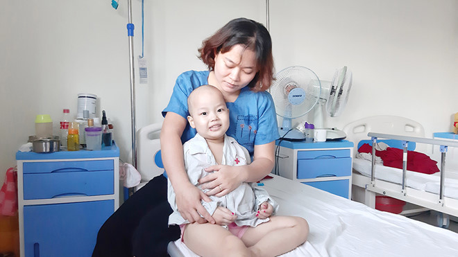 Cháu Ngân trong vòng tay mẹ với nụ cười ngây thơ tại bệnh viện Lời khẩn cầu nhói lòng của cháu bé 4 tuổi