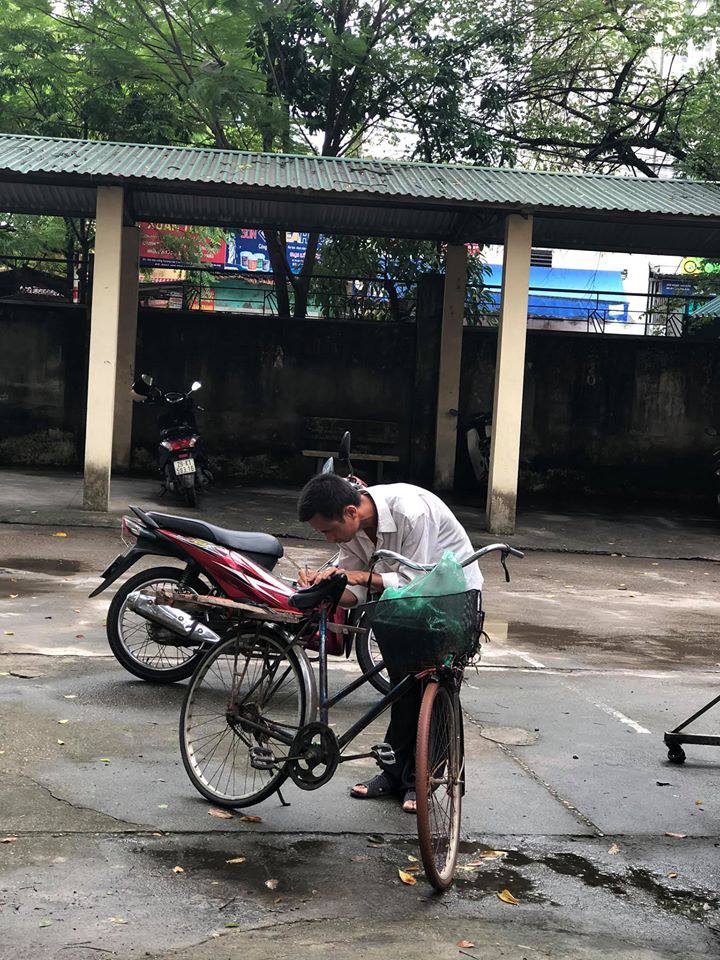 Bất kể mưa gió, người cha già đạp xe tới tận trường THPT xem điểm thi cho con