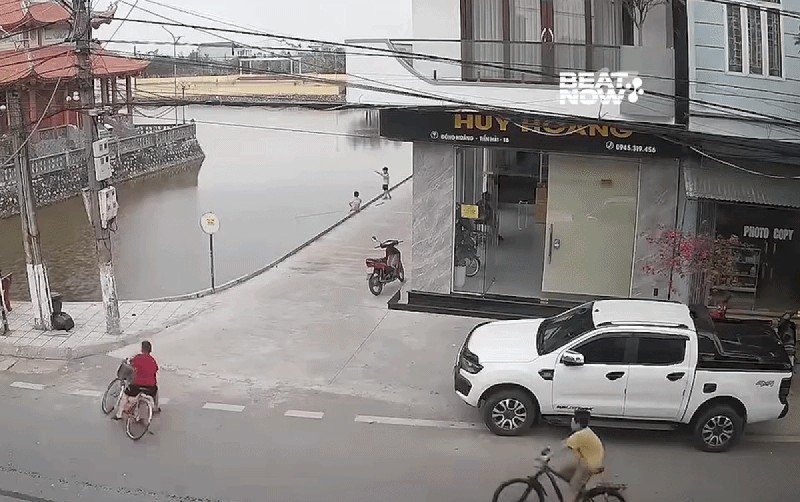 Cua gấp lại chạy tốc độ nhanh, bé trai và xe đạp lao xuống dòng sông. Ảnh cắt từ clip